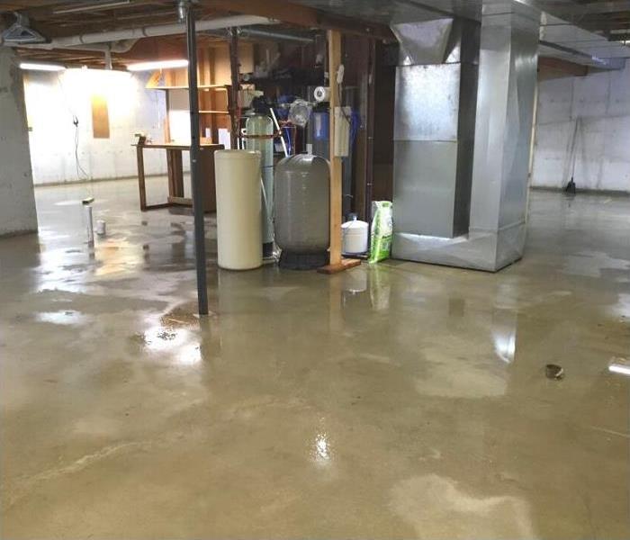 Unfinished basement floor with water damage