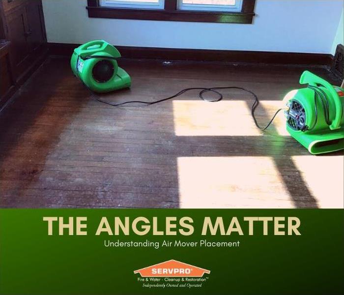Image of air movers drying out an empty room with wood floors.