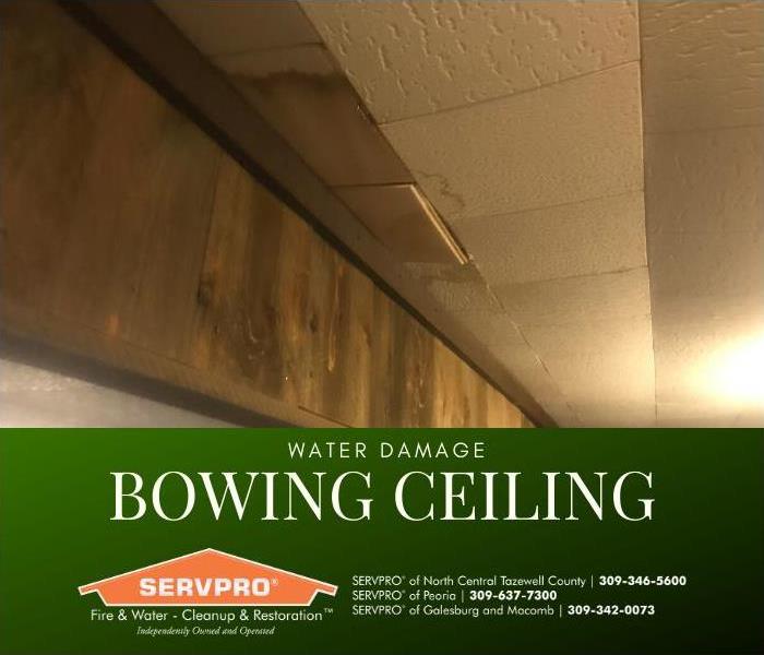 Tile ceiling is bowing from the weight of water damage.